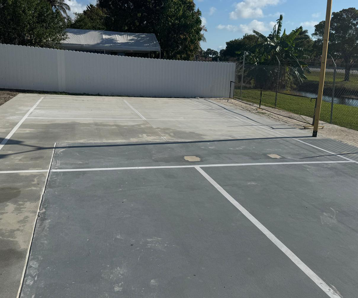 Empty outdoor basketball court under blue sky.
